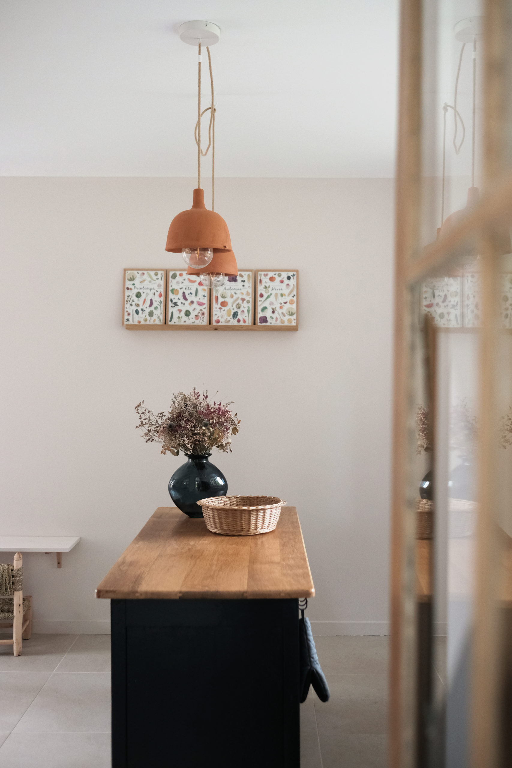 Ilot central surmonté d'un vase avec des fleurs séchées, dans une cuisine